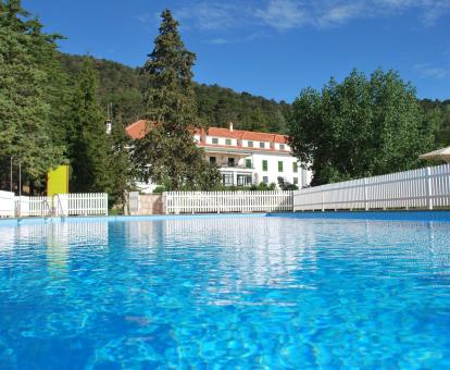 Foto de la piscina al aire libre rodeada de naturaleza del hotel.