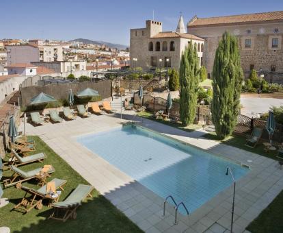 Foto de la piscina al aire libre del hotel con solarium y tumbonas.
