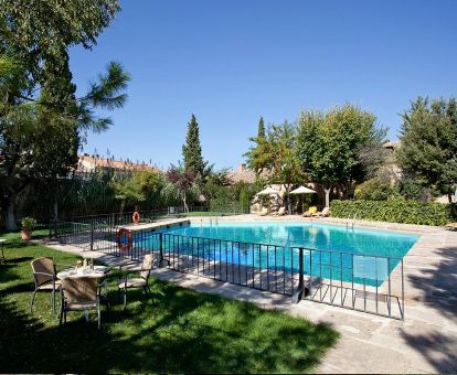 Agradable zona exterior rodeada de jardines con piscina y solarium.
