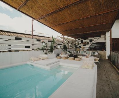 Terraza con mobiliario y piscina de este acogedor hotel solo para adultos.