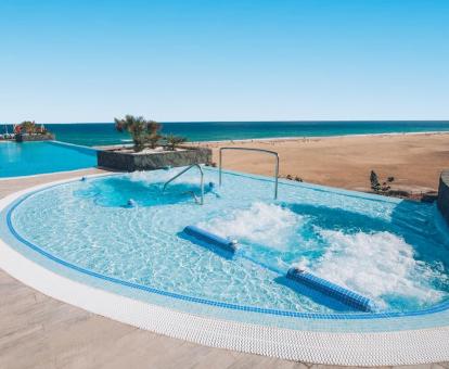 Foto de una las piscinas al aire libre con hermosas vistas a la playa.