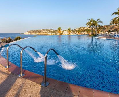 Gran piscina exterior con chorros de hidroterapia y vistas al mar de este romántico hotel.