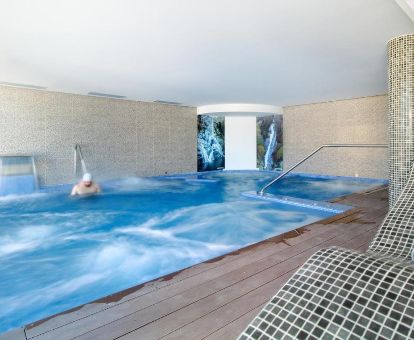 Piscina con elementos de hidroterapia del centro de bienestar de este romántico hotel ideal para parejas.