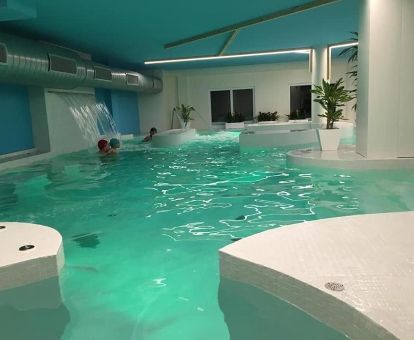Varias personas disfrutan de las instalaciones del spa de este coqueto hotel para parejas.