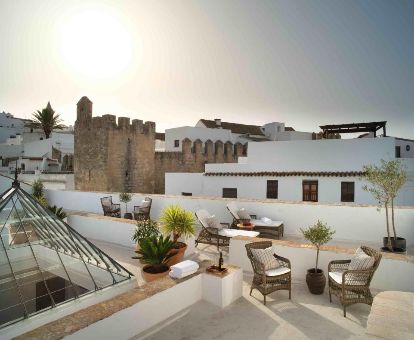 Terraza con mobiliario y vistas a la ciudad de este acogedor hotel solo para adultos.