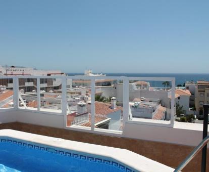 Foto de la terraza superior del complejo con piscina y vistas al mar.