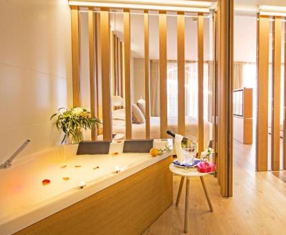 Suite Deluxe con bañera de hidromasaje privada cerca de la cama y vistas al mar.