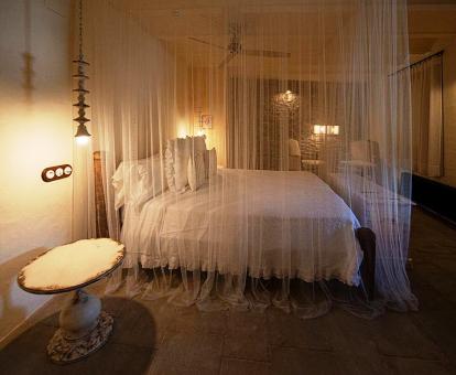 Foto de una de las habitaciones del hotel con cama extragrande y dosel.