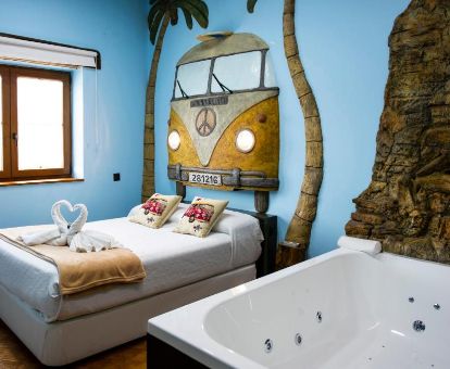 Habitación Doble Deluxe con bañera de hidromasaje privada junto a la cama en este romántico hotel.