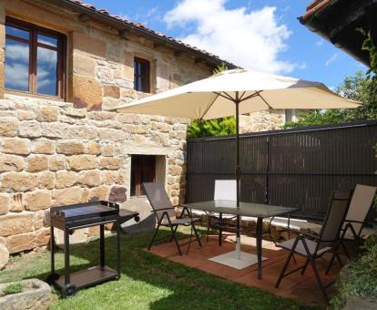 Foto del jardín privado con comedor y barbacoa de esta acogedora casa rural.