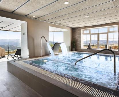 Foto de la piscina de hidroterapia del hotel con zona de relajación y vistas a las montañas.