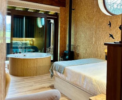 Hermosa suite deluxe con bañera de hidromasaje privada junto a la cama en este coqueto hotel ideal para parejas.