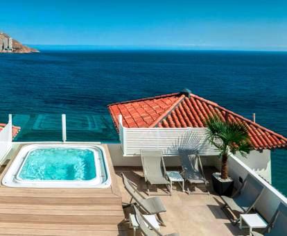 Foto de la terraza con jacuzzi al aire libre y vistas al mar.