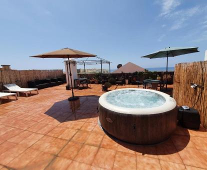 Foto de la terraza comunitaria con solarium, jacuzzi exterior y vistas al mar de este establecimiento.