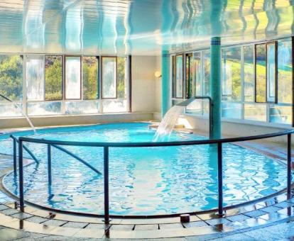Foto de la piscina cubierta disponible todo el año con elementos de hidroterapia del spa.