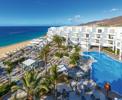 Fabuloso hotel con zonas exteriores y piscina en primera línea de playa.
