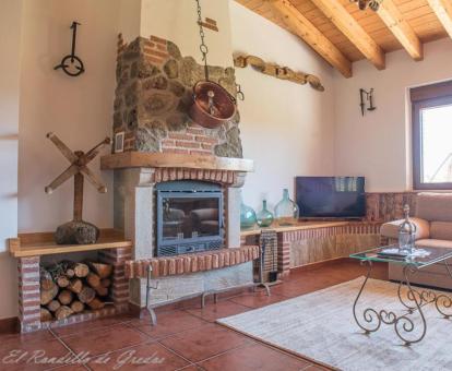 Foto de la sala de estar con televisión y chimenea de una de las casas del establecimiento.