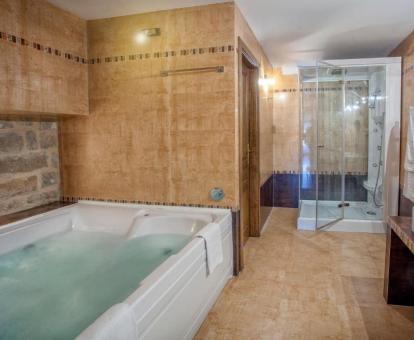 Precioso baño con un gran jacuzzi privado y ducha de hidromasaje de la suite junior de este hotel.