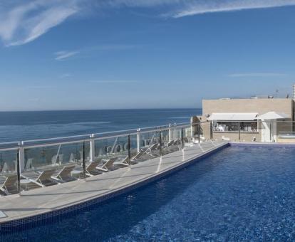 Foto de la piscina al aire libre con tumbonas y vistas al mar.