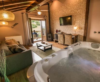 Suite con bañera de hidromasaje y sala de estar independiente de este romántico hotel.