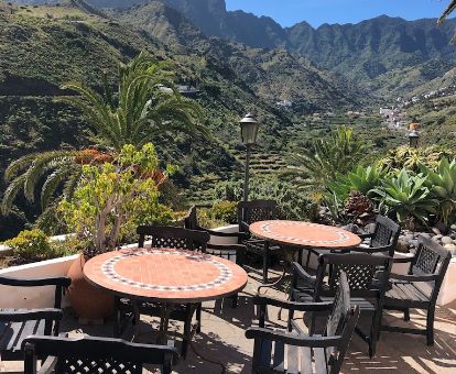 Terraza con comedores y vistas al valle y a las montañas frente a este hermoso hotel rural.