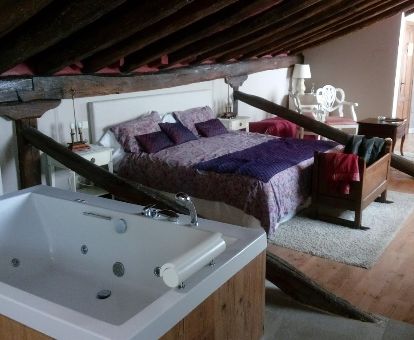 Una de las maravillosas habitaciones con bañera de hidromasaje privada junto a la cama del hotel.