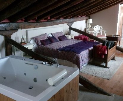 Una de las maravillosas habitaciones con bañera de hidromasaje privada junto a la cama del hotel.