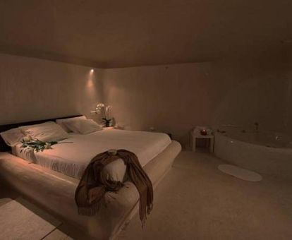 Dormitorio con bañera de hidromasaje privada junto a la cama de una de las cuevas independientes de este complejo rural.
