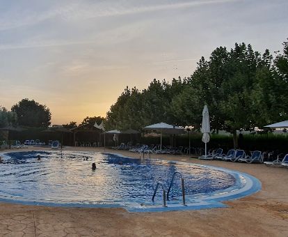 Amplia zona exterior con piscina al aire libre rodeada de vegetación de este hotel rural.