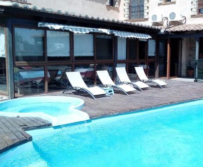 Agradable zona exterior con piscina, tumbonas y jacuzzi en este hotel rural.