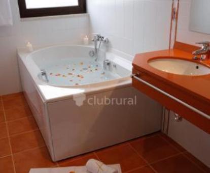 Bañera de hidromasaje privada en el baño de la habitación con cama grande del hotel.