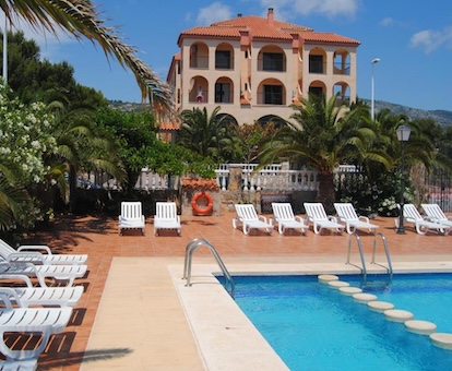 Edificio de este hotel sencillo con amplia piscina exterior y jardín.