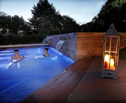 Pareja disfrutando de la piscina exterior con chorros de hidroterapia de este hotel romántico.