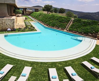 Foto de la piscina del hotel con solarium rodeada de tumbonas.