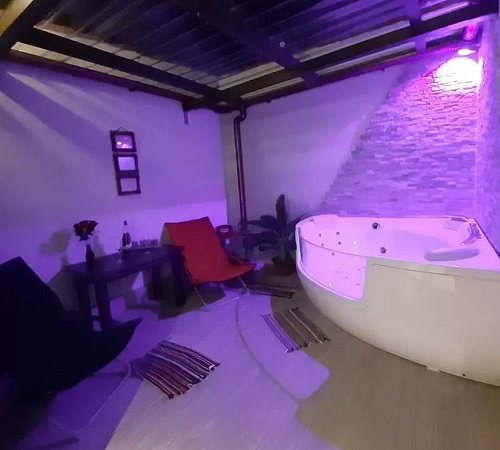 Foto del jacuzzi en Casas Toya que se encuentra bajo un techo de cristal y con una luz rosa sobre el jacuzzi
