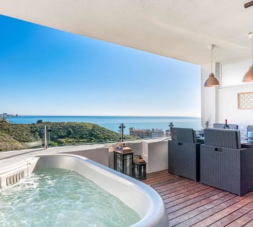 Foto del jacuzzi con vistas al mar de Fuengirola junto a la mesa para comer en la terraza del apartamento Carvajal Luxury Apartments