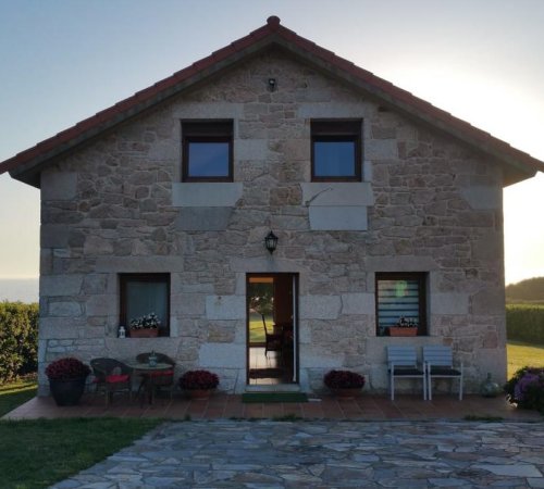 Foto de la Casa Cubelas en Porto do Son donde se ve el estilo rústico de la casa por fuera y parte del entorno natural que hay alrededor