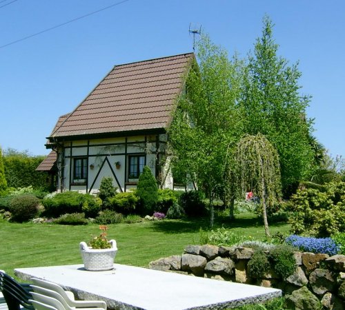 Foto del exterior de la casa Los Arces con los jardines y el cesped en los alrededores de la casa