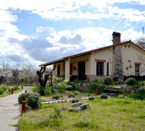 Vista desde el exterior desde el jardín de la casa rural Casa Valeriana donde se vé el camino de piedras que lleva hasta la casa.