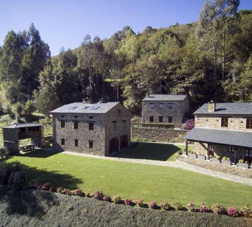 Foto desde lejos del Complejo Rural Casona de Labrada donde se ven las casas individuales disponibles para los clientes y el entorno natural de gran belleza