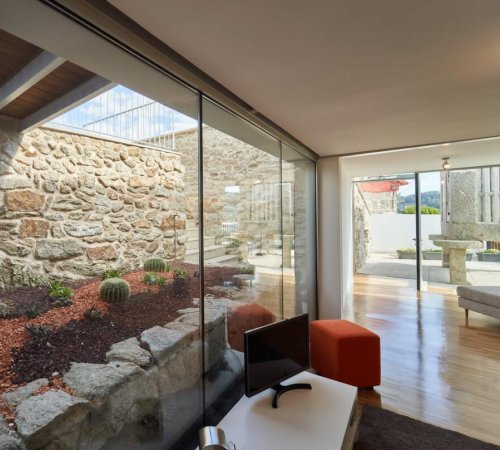 Vista interior de la Casa para 2 personas de Views and Beds donde se ve la decoración del interior y parte de los jardines del exterior