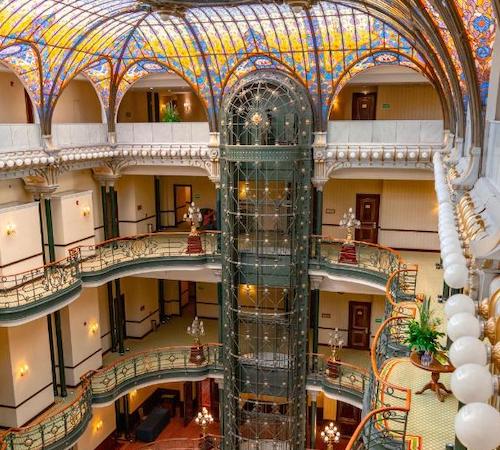 Vista del hall del Gran Hotel Ciudad de Mexico donde se ven las 4 plantas y las vidrieras del techo en forma de bóveda