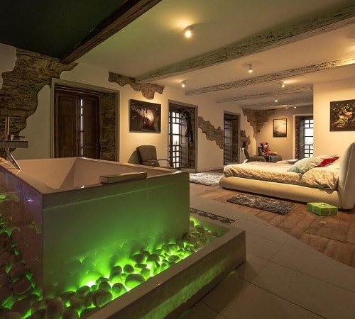 Jacuzzi junto a la cama en medio de la habitación doble Deluxe en el alojamiento solo para adultos As Casas Do Retratista en Vileimil