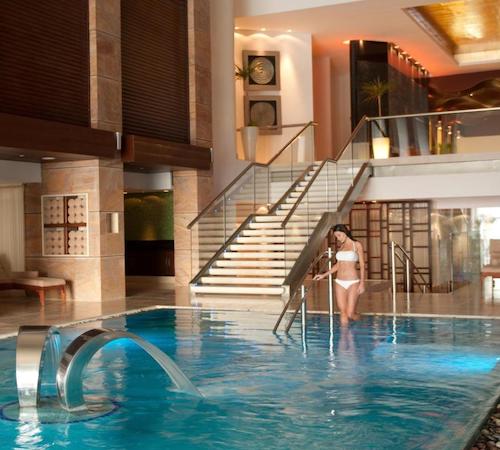 Mujer entrando a una piscina con chorros de agua de hidromasaje en el spa del hotel Grand Fiesta Americana Coral Beach Cancun