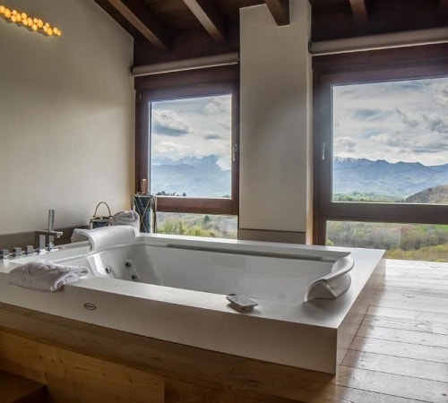 Jacuzzi junto a la ventana con vistas al campo en el hotel Puebloastur Eco Resort Wellness