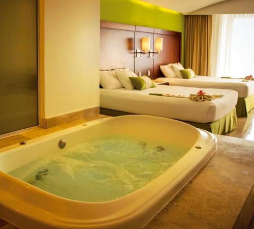 Jacuzzi privado junto a las camas para dos personas en la Suite de lujo del hotel Azul Ixtapa Grand All Inclusive Suites - Spa & Convention Center