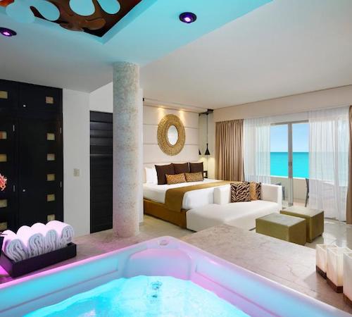 Vista desde el jacuzzi con cromoterapia desde la que se ve la cama a pocos metros en la Suite Pasión del Hotel Desire Riviera Maya Resort en Puerto Morelos