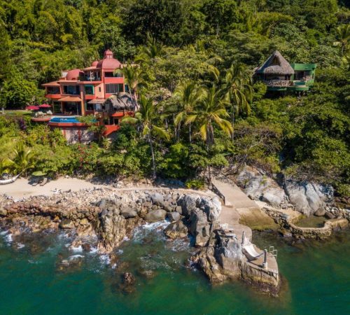 Foto del hotel en mita de la selva y un jardín enfrente a pocos metros de un acantilado frente al mar