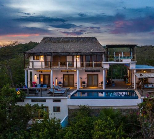Casa rodeada de selva con una piscina frente al hotel y otra piscina elevada en la casa de dos plantas de Casa Kalmar Adults Only