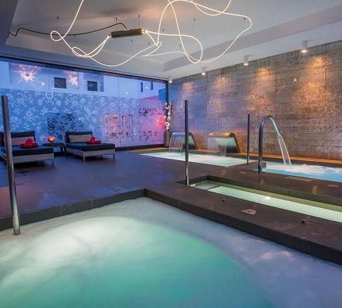 Foto de la zona de spa en el hotel Migjorn Ibiza Suites & Spa donde se puede ver la piscina de hidroterapia, jacuzzi y zona de estar para relajarte
